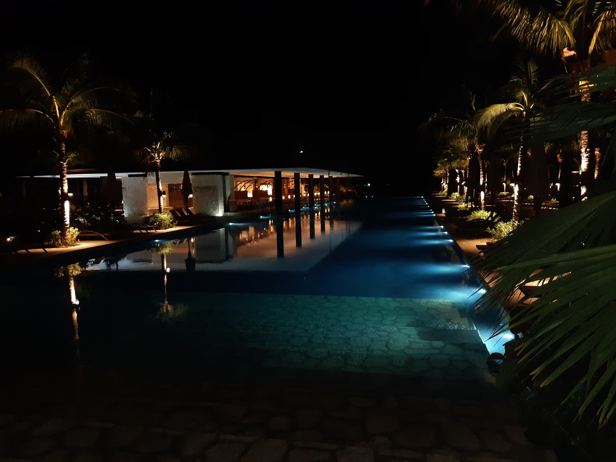Luxury villa with illuminated pool at night